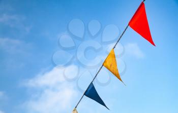 Colorful triangle flags banner on blue cloudy sky background