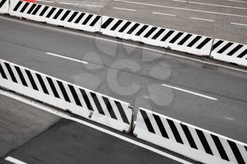 Asphalt road with striped white concrete border blocks