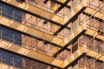 Abstract modern architecture fragment, walls made of gold toned glass with sun reflections