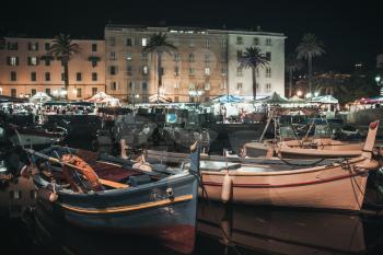 Wooden fishing boat moored in old port of Ajaccio, the capital of Corsica island, France. Night photo with warm vintage tonal correction filter