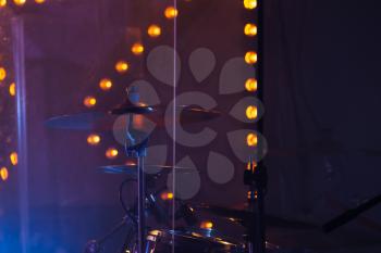 Live rock music photo background, rock drum set  with cymbals in dark stage lights. Close-up photo, soft selective focus