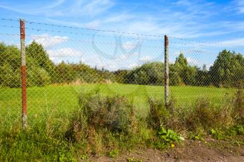 Rural summer Finnish landscape with Chain-link fencing