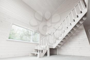 Empty new wooden house interior with stairway and window
