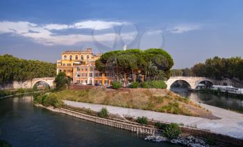 Cityscape of old Rome in summer evening. The Tiber Island in southern bend of Tiber river