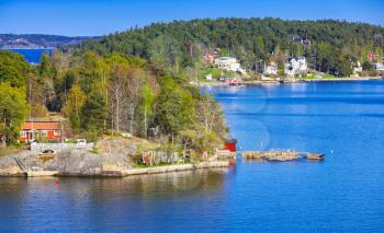 Rural Swedish landscape with coastal villages. Bright wooden houses and barns on rocky islands