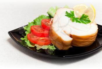 Seafood theme. Smoked calamari with vegetables and greens on black plate, closeup photo