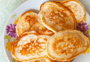 Traditional Russian homemade small pancakes on the colorful plate