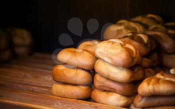Freshly baked warm traditional Russian pies on wooden counter in bakery. Selective focus