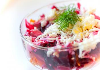 Traditional Russian salad with herring and beet. Closeup photo with selective focus