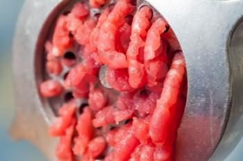 Macro photo of mincer machine with fresh chopped meat