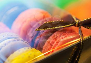 Macro with colorful macaroons in the gift box with tape. Macro photo with shallow depth of field