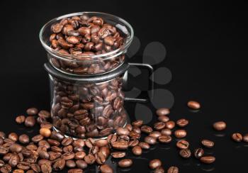Mug with whole roasted coffee beans on black
