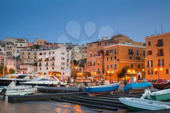 Old port with moored motorboats and yachts. Night cityscape of Gaeta town, Italy