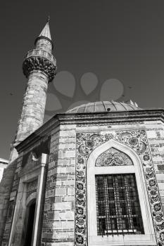 Ancient Camii mosque, facade fragment with minaret. Konak square, Izmir, Turkey. Monochrome photo