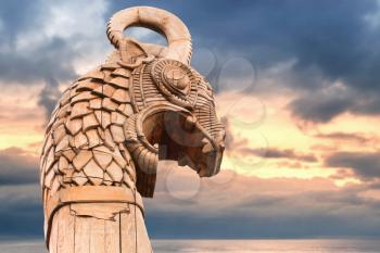 Carved wooden dragon on the bow of Viking ship above morning sky and sea