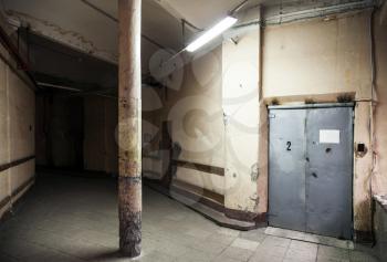 Empty dark industrial hall interior with metal elevator door