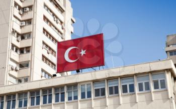 Banner with national flag of Turkey mounted on modern building facade in Izmir city