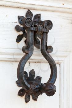 Vintage black metal knocker on white wooden door