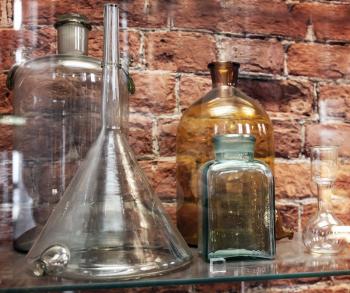 Vintage chemical ware is on the shelf on brick wall background
