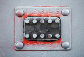 Old code lock with buttons on gray metal door