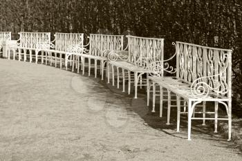 White park benches in the row. Retro stylized photo