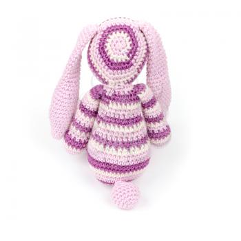 Knitted rabbit toy sitting isolated on white background, back view