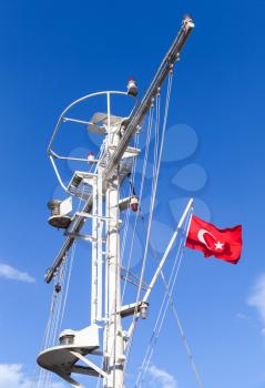 White ship mast with the Turkish flag over blue sky background