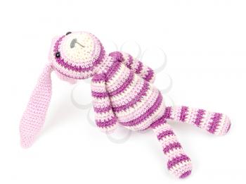 Knitted rabbit toy is sitting and looks up, photo isolated on white background
