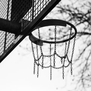 Basket made of chains for basketball playing on the playground in a city park, black and white photo