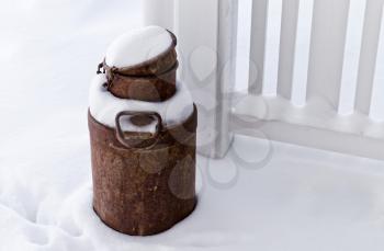 Old rusted can on snow-covered terrace in Finland