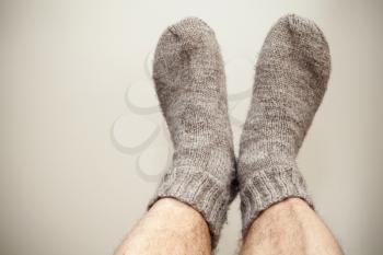 Closeup photo of male feet with gray woolen socks 