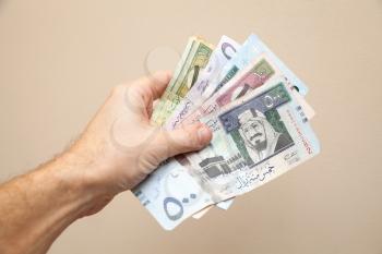 Modern Saudi Arabia money, banknotes in male hand, close-up photo