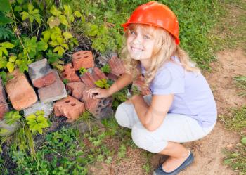 Portrait of smiling young girl plays as a construction worker