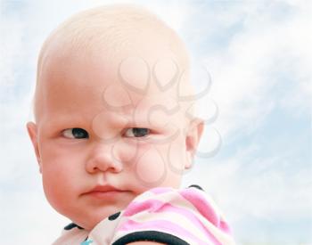 Funny baby girl outdoor summer close up portrait above cloudy sky