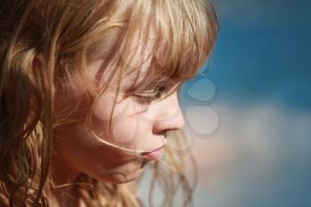 Closeup profile portrait of calm little blond girl