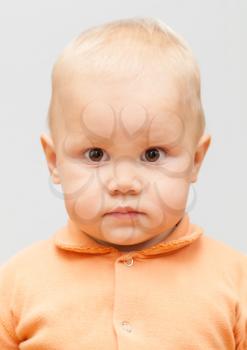 Closeup studio face portrait of Caucasian baby girl isolated on gray background
