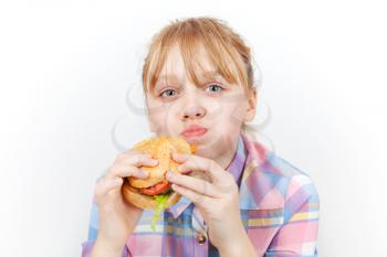 Little blond girl eats burger on white background