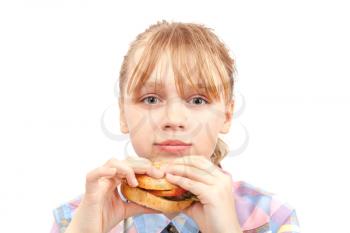 Little blond girl eats hamburger. Portrait isolated on white
