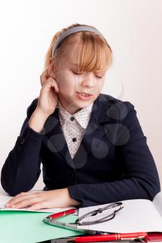 Portrait of tired blond Caucasian schoolgirl with headache