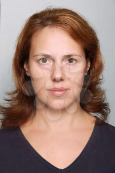 Young Caucasian woman closeup portrait. Headshot on gray