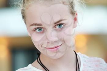 Closeup outdoor portrait of beautiful happy blond Caucasian teenage girl
