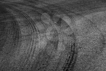 Dangerous turn. Abstract road background with tires tracks on dark asphalt