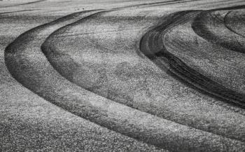 Abstract background with curved tires tracks on dark asphalt road