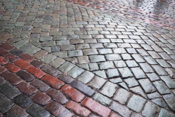Background texture of wet granite cobblestone urban road