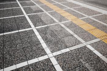 White and yellow road marking lines on gray cobblestone pavement, abstract urban background pattern