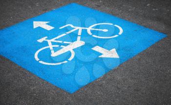 Bicycle lane. Closeup photo of blue and white road marking over urban asphalt road