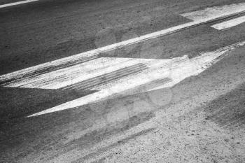 Road marking with tire tracks on gray asphalt