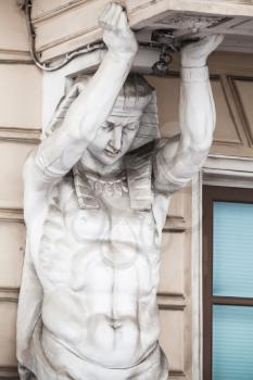 Atlas as decorative column element of the facade of an old classical building in Saint-Petersburg, Russia