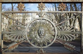 Frontal view of lion head in round frame. Decoration of old metal fence in central historical part of Saint-Petersburg, Russia