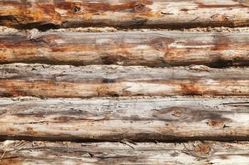 Old wooden wall made of logs, close-up background photo texture